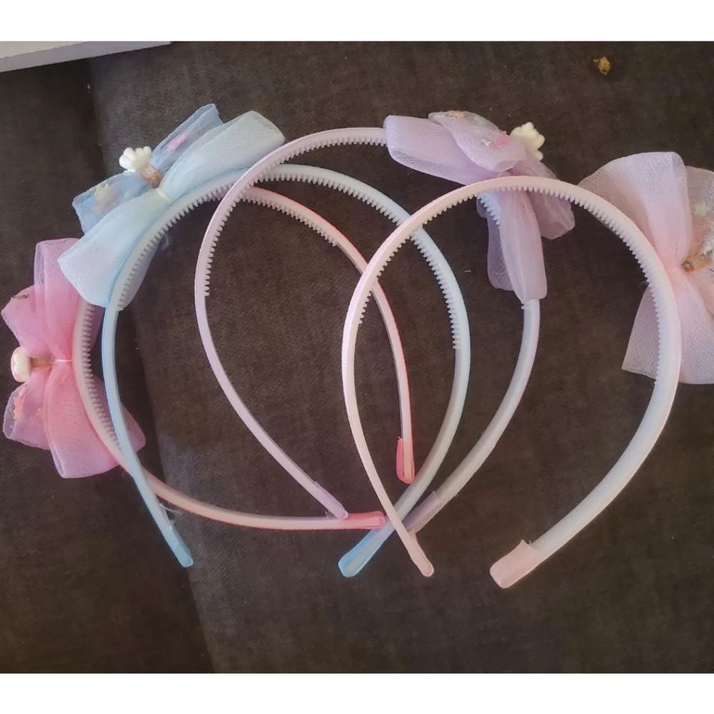 Four Hello Kitty headbands with small figurine